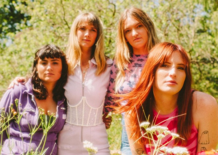 Four woman dressed in pink & purple in a fieldx